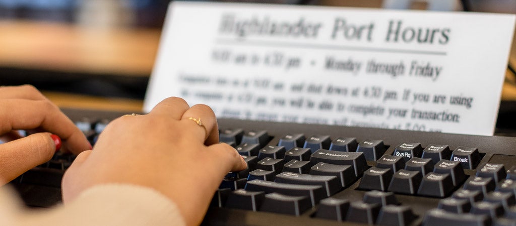 A student uses a keyboard at one of the Highlander Port workstations in the Highlander One-Stop Shop (HOSS).