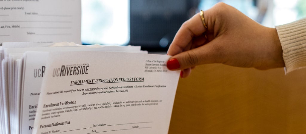 A UCR student picks up an Enrollment Adjustment Form from the Highlander One-Stop Shop (HOSS). 