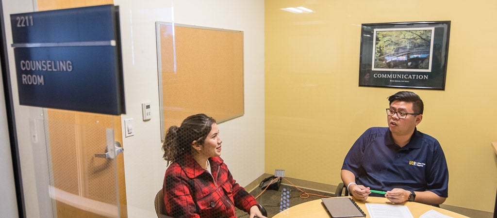 A UCR student meets with a registrar in a counseling room. 